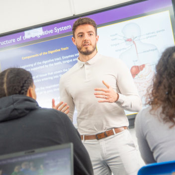 Tutor talking at the front of a classroom