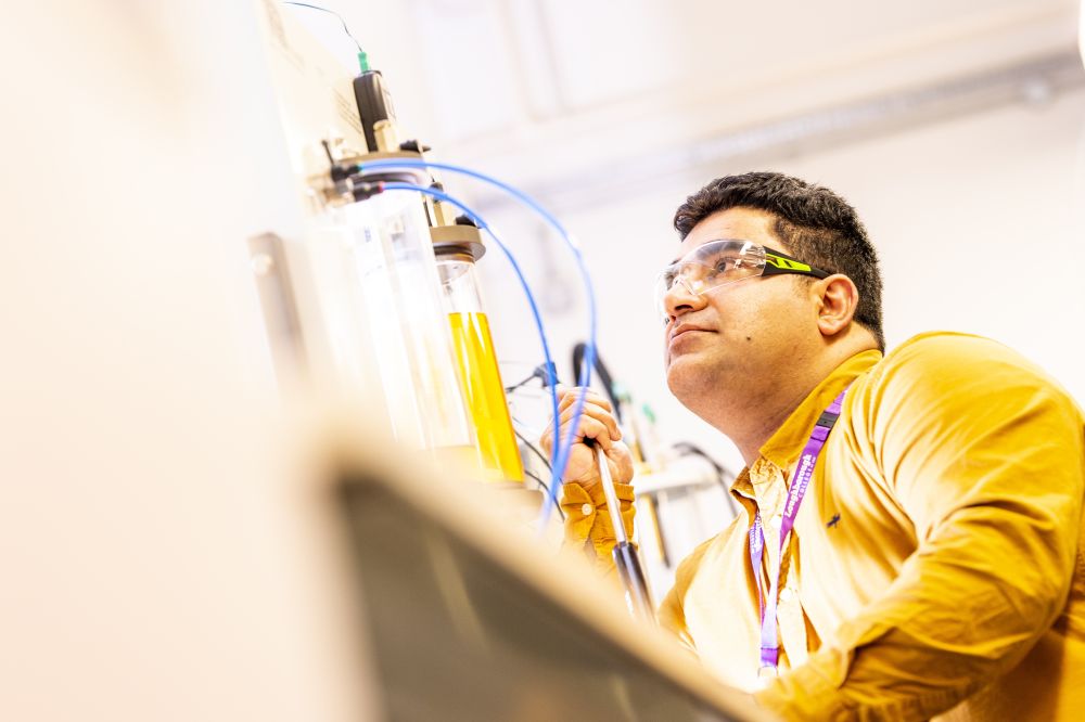 A Photo of a Sustainable Engineering Student looking at a piece of equipment 