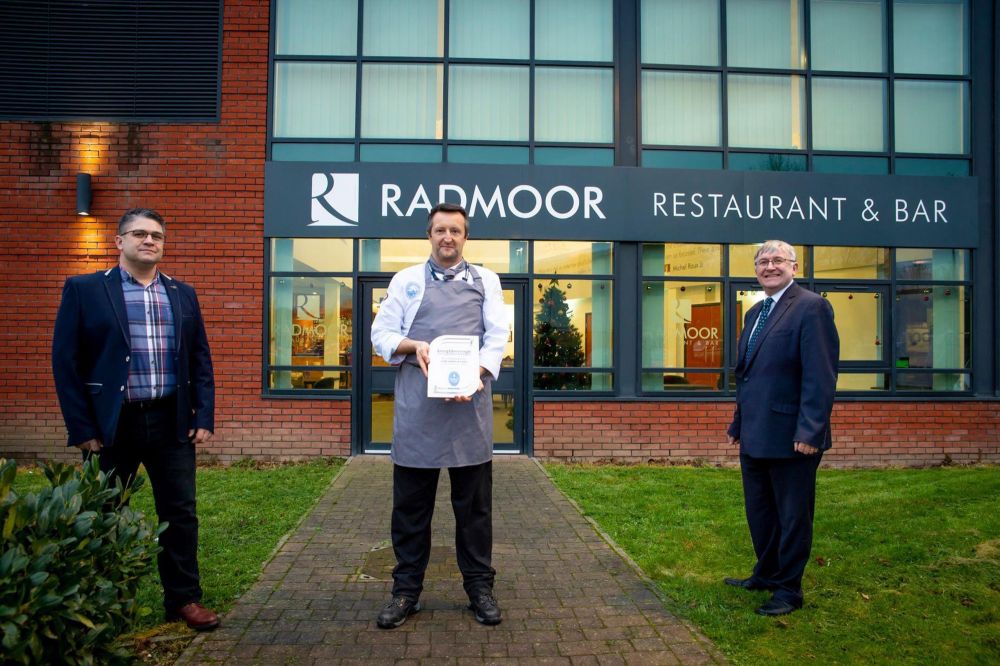 Darren Creed, Curriculum Manager for hospitality and Loughborough College standing outside of the Radmoor Centre holding an award
