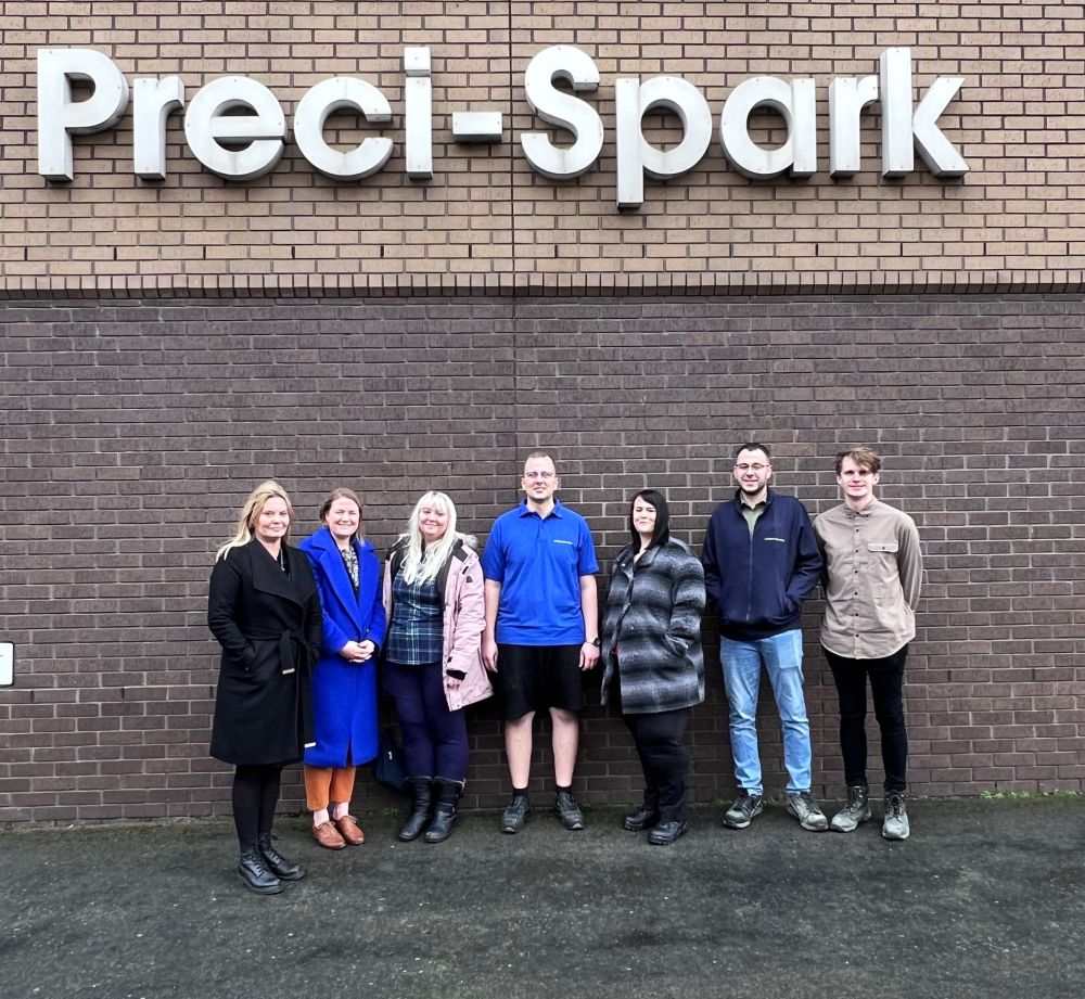 Staff and apprentices stand by the Preci-Spark building